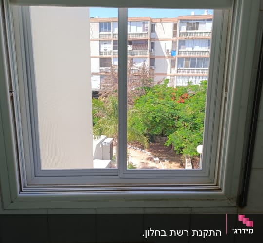 חלון עם תריסים נגללים במבט מבחוץ
